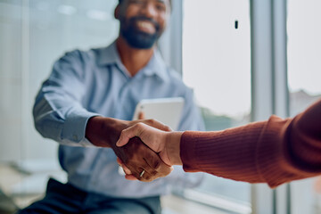 Two business professionals shaking hands, symbolizing successful partnership, agreement, deal, and collaboration in an office setting © we.bond.creations