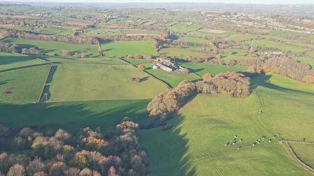Winding secondary road and typical West Yorkshire dry stone wall boundary separating expansive green agricultural fields from the industrial proximity of the Caphouse Colliery area.
