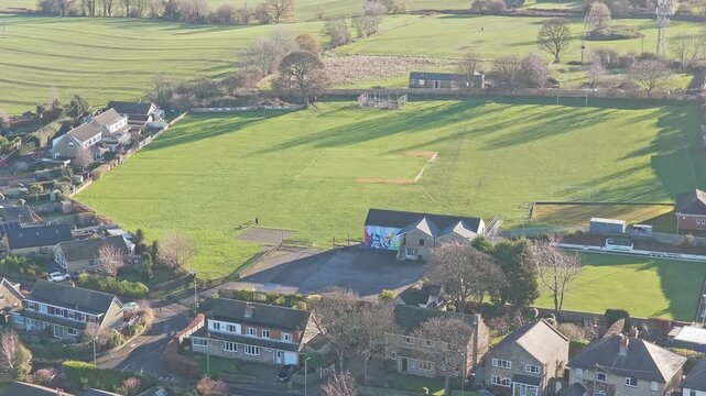 Drone's low-altitude perspective captures rows of modern suburban housing and established gardens in the Overton district, adjacent to heritage site of Caphouse Colliery in West Yorkshire.