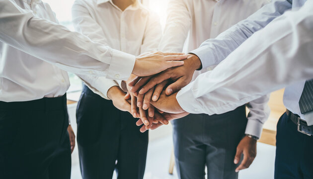 手を重ねて結束を示すビジネスチームの象徴表現