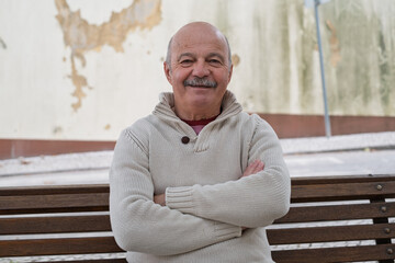 Fototapeta premium An elderly Spanish man is resting while sitting on a bench, enjoying a quiet moment outdoors 