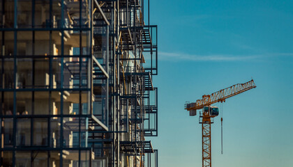 高層ビル建設現場に立つタワークレーンの風景