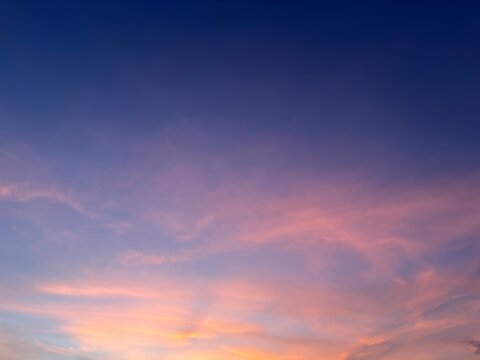 Beautiful sunset sky with soft clouds and smooth gradient colors from blue to pink and orange. Natural evening atmosphere, calm mood, perfect for background, wallpaper, and nature concepts.