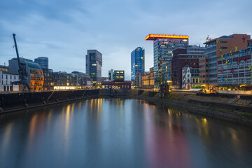 View of reflections of vibrant buildings dance on the tranquil water under the twilight sky, a blend of modern architecture and serene waterscape, Dusseldorf, Dusseldorf, Germany.