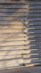 Modern Architectural Facade With Horizontal Wooden Slats And Concrete Wall With Soft Sunlight And Shadows