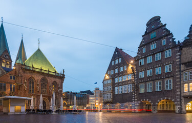 View of the Weser Renaissance architecture with its ornate brickwork, illuminated windows, and pointed spires rising against the twilight sky, Bremen, Bremen, Germany.