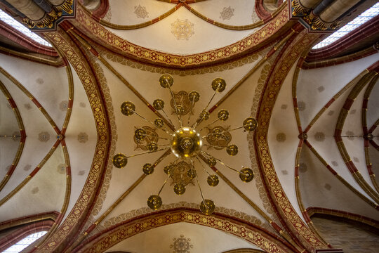 View of an ornate ceiling with intricate patterns radiating from a central chandelier, showcasing a blend of colors and architectural details, Bremen, Bremen, Germany.