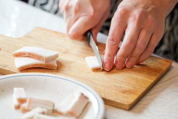 Obraz premium Culinary preparations a culinary artist slicing a white sweet treat with precise knife work on a wooden cutting board