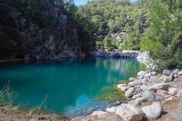 Small pond in the mountains with turquoise water in Goynuk canyon,  Turkey. Emerald lake in the forest surround mountains.