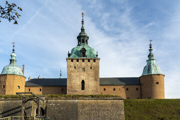 View of the majestic Kalmar Castle with its copper-green towers piercing the clear blue sky, a testament to history and architectural grandeur, Kalmar, Kalmar County, Sweden.