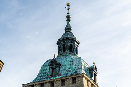 View of an old stone tower of Kalmar Castle with a weathered green copper roof rising against the clear blue sky, topped with a golden orb, Kalmar, Kalmar County, Sweden.