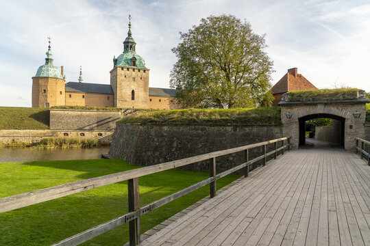View of the sturdy Kalmar Castle standing guard over placid waters, its golden walls reflecting the soft glow of a September afternoon, Kalmar, Kalmar County, Sweden.