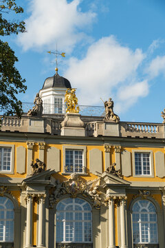 View of ornate statues standing proudly atop a golden-trimmed koblenzer Tor building under a bright blue sky, Bonn, North Rhine-Westphalia, Germany.