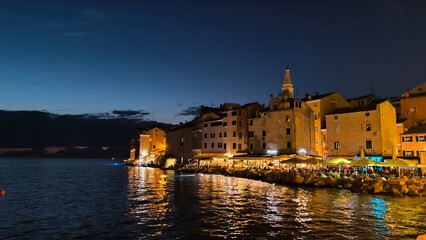 panorama of  illuminated Rovinj seen from the harbor at dusk
