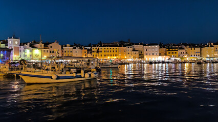 panorama of  illuminated Rovinj seen from the harbor at dusk