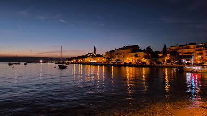 Fototapeta premium panorama of illuminated Rovinj seen from the harbor at dusk