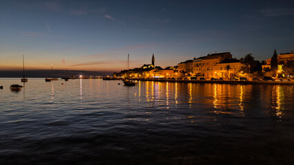 Obraz premium panorama of illuminated Rovinj seen from the harbor at dusk