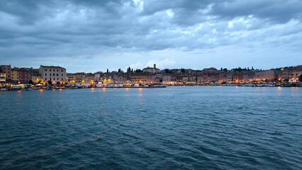 panorama of  illuminated Rovinj seen from the harbor at dusk