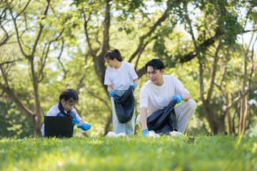 Fototapeta premium Asian family collects plastic bottles into black bags at a park on the weekend, Sustainable development and innovation green business concept.