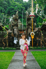 Balinese Woman in Traditional Kebaya with Namaste Gesture in Front of Pura