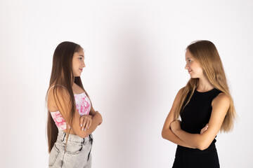 Two teenage girls standing and looking away from each other in studio