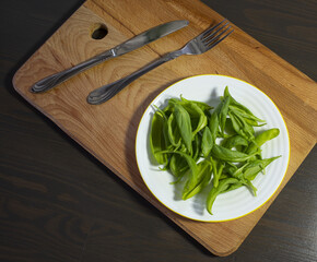 a plate of spinach and cutlery on the kitchen table