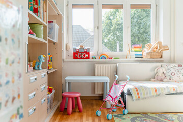 Tidy children room. Interior decor of clean children's room. Organizing storage in kids room: bookshelves and educational and soft toys. Montessori education. A childs bedroom with toys and books.