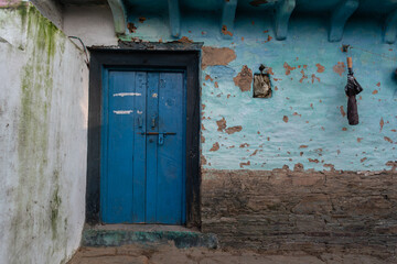 A village house made of mud and stone with wooden doors.
