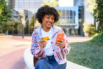 Smiling woman shopping online with credit card and smartphone