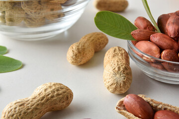 Detail of peeled peanuts in glass bowl on a white table