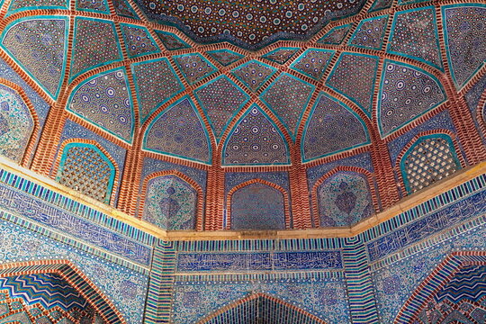 View of intricate blue and brown tilework adorning the walls and ceiling, creating a mesmerizing display of Islamic art, Thatta, Sindh, Pakistan.