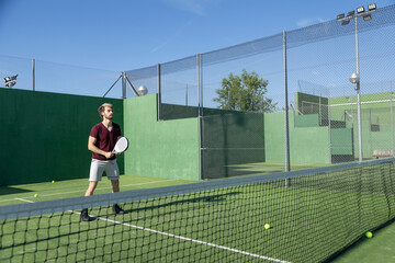 Obraz premium Man playing padel on outdoor court