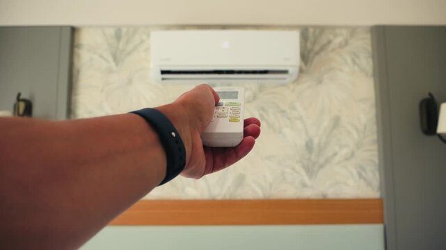 Close up of a hand holding an air conditioner remote pointing. Hand using remote controller for adjust Air conditioner. High quality 4k footage