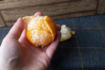 Gently grasped peeled citrus wedges in soft natural light during casual snack time
