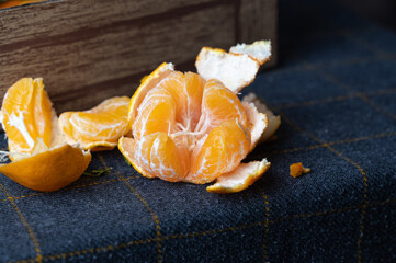 Rustic scene featuring peeled tangerine with scattered skins and natural lighting ambiance