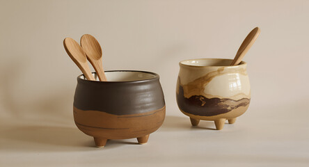 A warm, minimalistic product photo featuring two handcrafted ceramic vessels displayed side by side