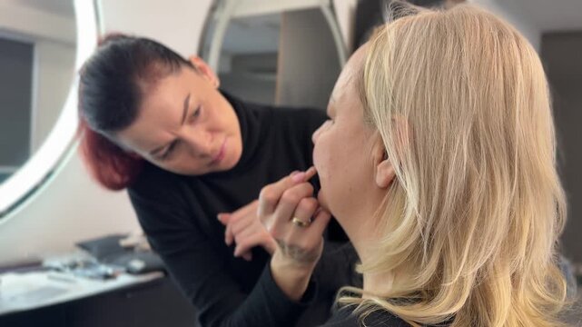 Makeup artist applying makeup on a client face Women, makeup artist and magazine cover. People, employee and smile with customer for cosmetics, makeover and glamour for beauty campaign