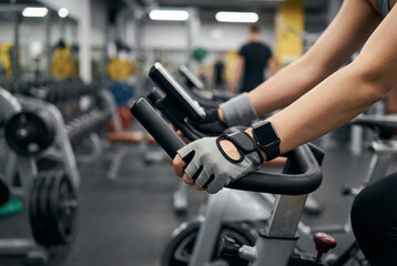 closeup of hands gripping bike handlebars amidst intense gym workout session