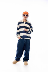 Teen in trendy striped polo and orange hat poses against a white background