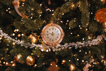 Magic golden clock, crystal beads and gold garland lights hanging on the Christmas tree, winter cozy details and decorations