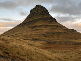 Kirkjufell mountain framed by a calm evening sky, with soft fading light enhancing the peaceful and scenic Icelandic surroundings.