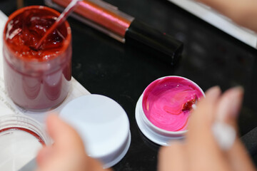 close-up of a woman's hand testing lip colors.