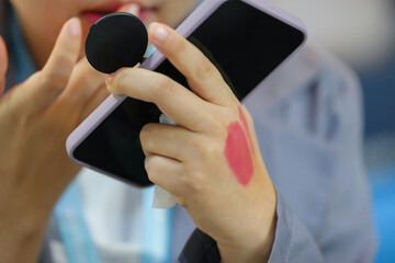close-up of a woman's hand testing lipstick swatches