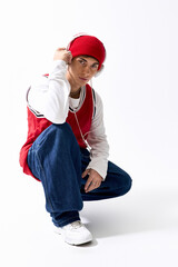 Stylish teenager showcases hip hop fashion with a red hat and baggy jeans