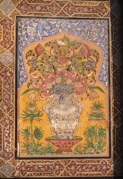 View of a vibrant, framed floral design with red and green tones, set against a yellow backdrop and intricate blue border, Lahore, Punjab, Pakistan.