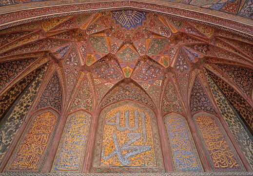 View of intricate tilework and calligraphy adorns the interior of a building, showcasing rich colors and geometric patterns, Lahore, Punjab, Pakistan.