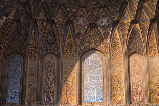View of ornate arches adorned with intricate floral and calligraphic designs under a soft light, creating a mesmerizing visual narrative, Lahore, Punjab, Pakistan.