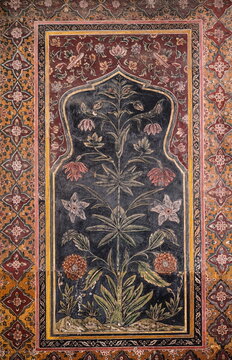 View of an archway with a black backdrop, adorned with an intricate floral design featuring red and white flowers, Lahore, Punjab, Pakistan.