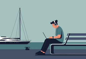 A man focuses on his laptop while listening to music, seated on a bench overlooking a sailboat. A serene, productive workspace scene.