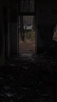 burnt brick entrance into woods. ruined doorway with tiled walls, charred lintel and collapsed floor, graffiti scars on ceramic tiles, view through hole to forest clearing salvage crew